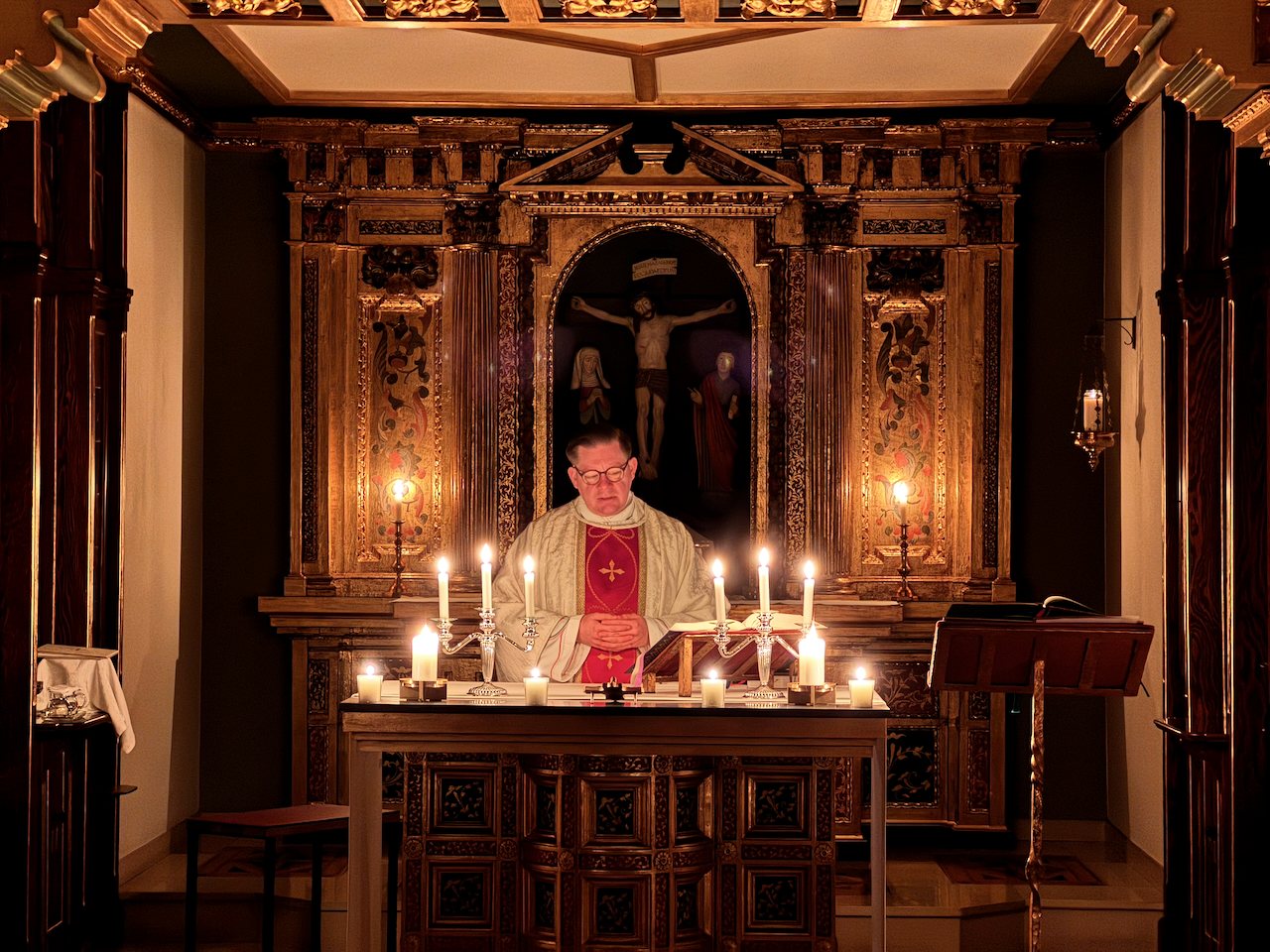 Heilige Messe bei Kerzenlicht in der Hauskapelle mit vergoldetem Altarretabel